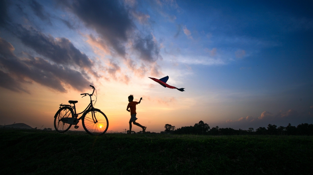 一个小男孩在日落下放风筝唯美意境图片