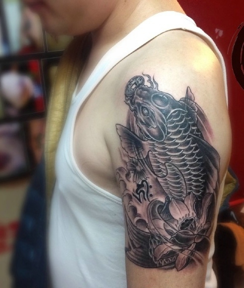 黑白鲤鱼和荷花结合的大臂刺青