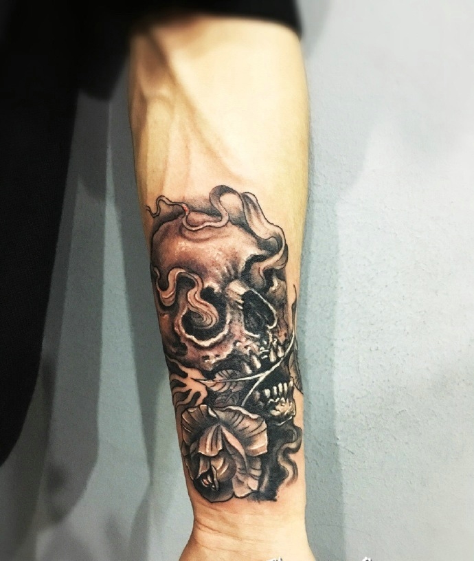 骷髅叼花个性手臂纹身图片