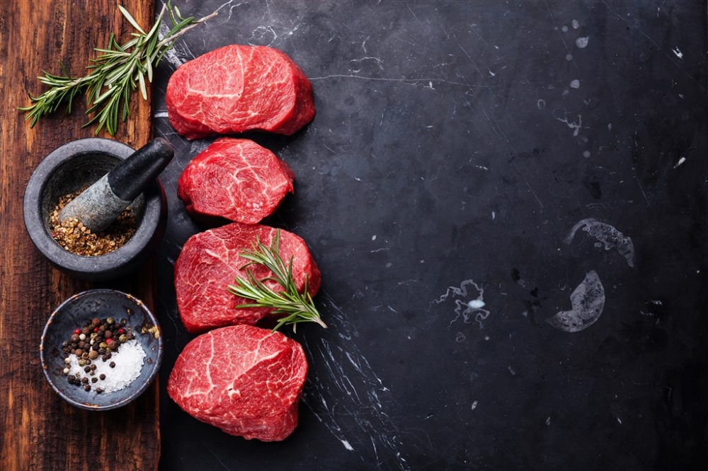 黑色石板上的四块生牛肉