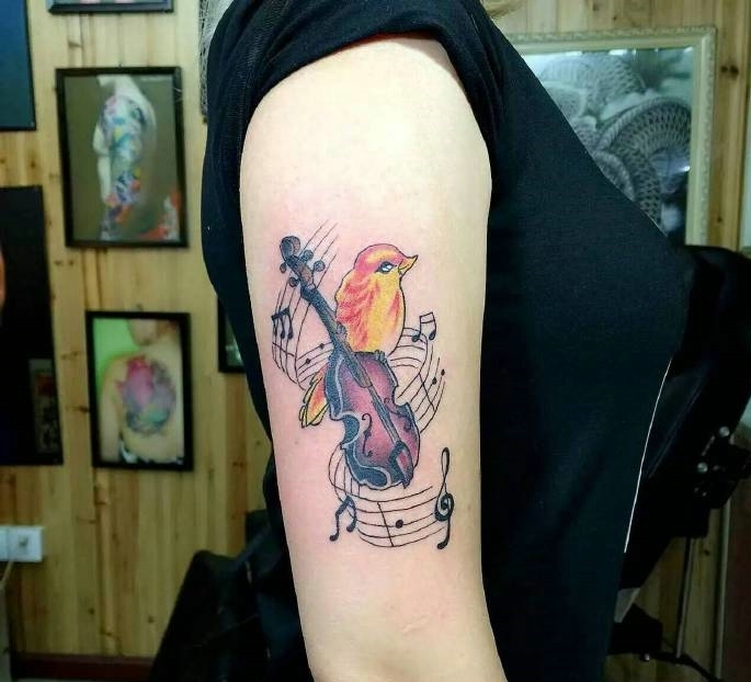 一只爱音乐的小鸟手臂纹身刺青