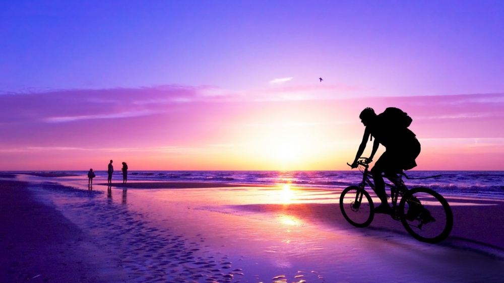 夕阳在海滩上游玩的人们高清电脑桌面壁纸