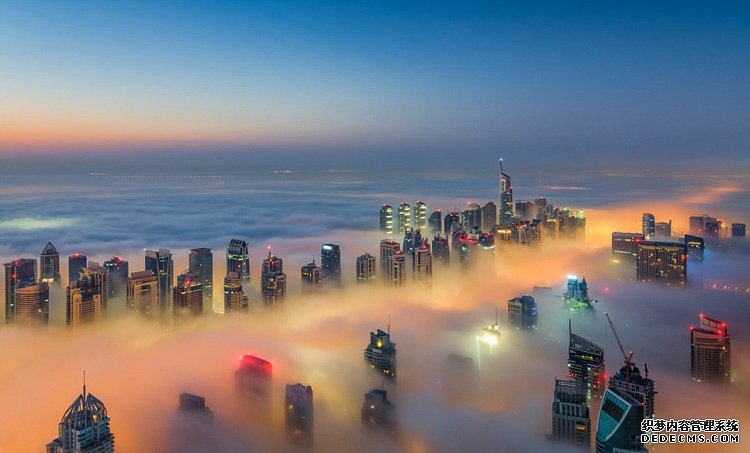 高空拍摄迪拜雾中的城市夜景图片