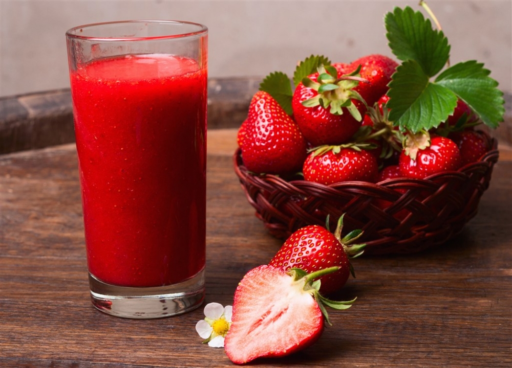 酒店木板上的鲜榨草莓水果果汁和果盘