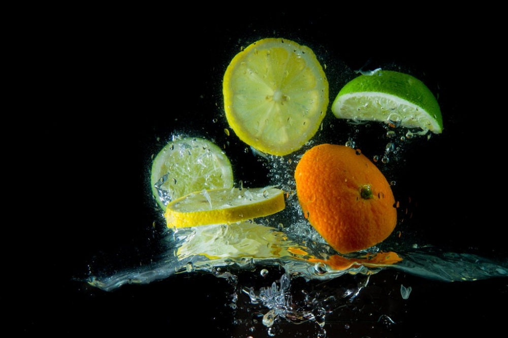 高清动态水中的水果柠檬片橘子片黑色背景图片素材