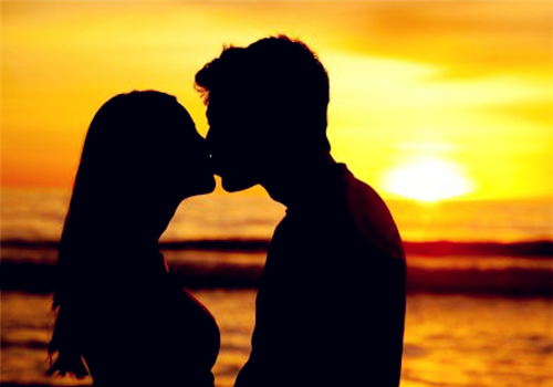 夕阳下甜蜜接吻的情侣图片
