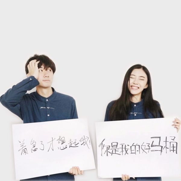 恩爱甜蜜的小情侣手举温馨表白文字接吻可爱搞怪创意的摆拍图片